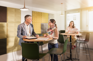 Mitarbeitende in einer Besprechung, offener Raum mit Lüftung